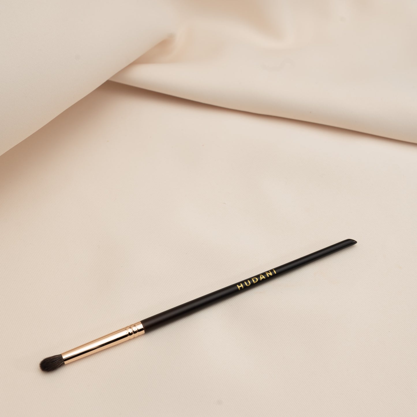 This is a fluffy rounded synthetic brush for your eyes and it has a wooden handle.