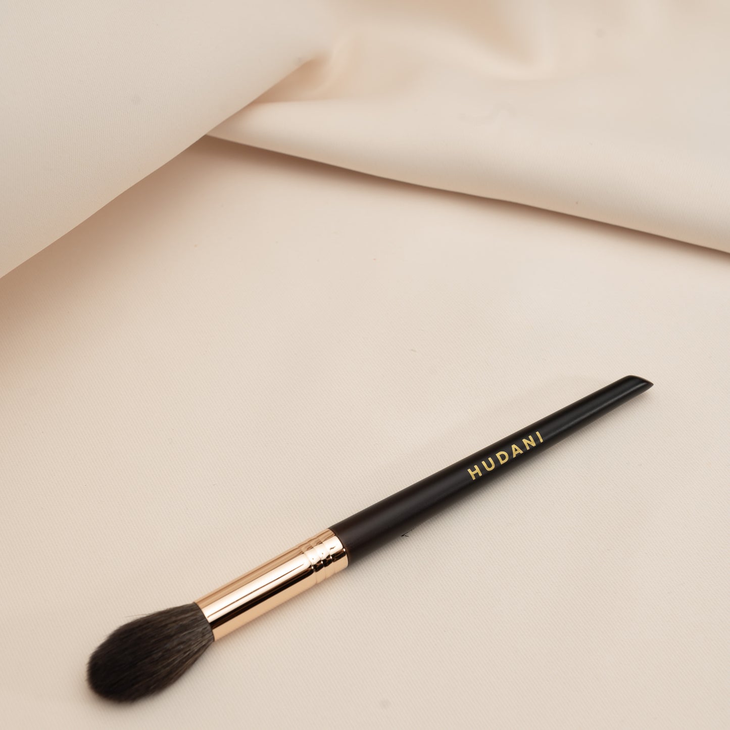 This is a tapered powder brush and it has a wooden handle.