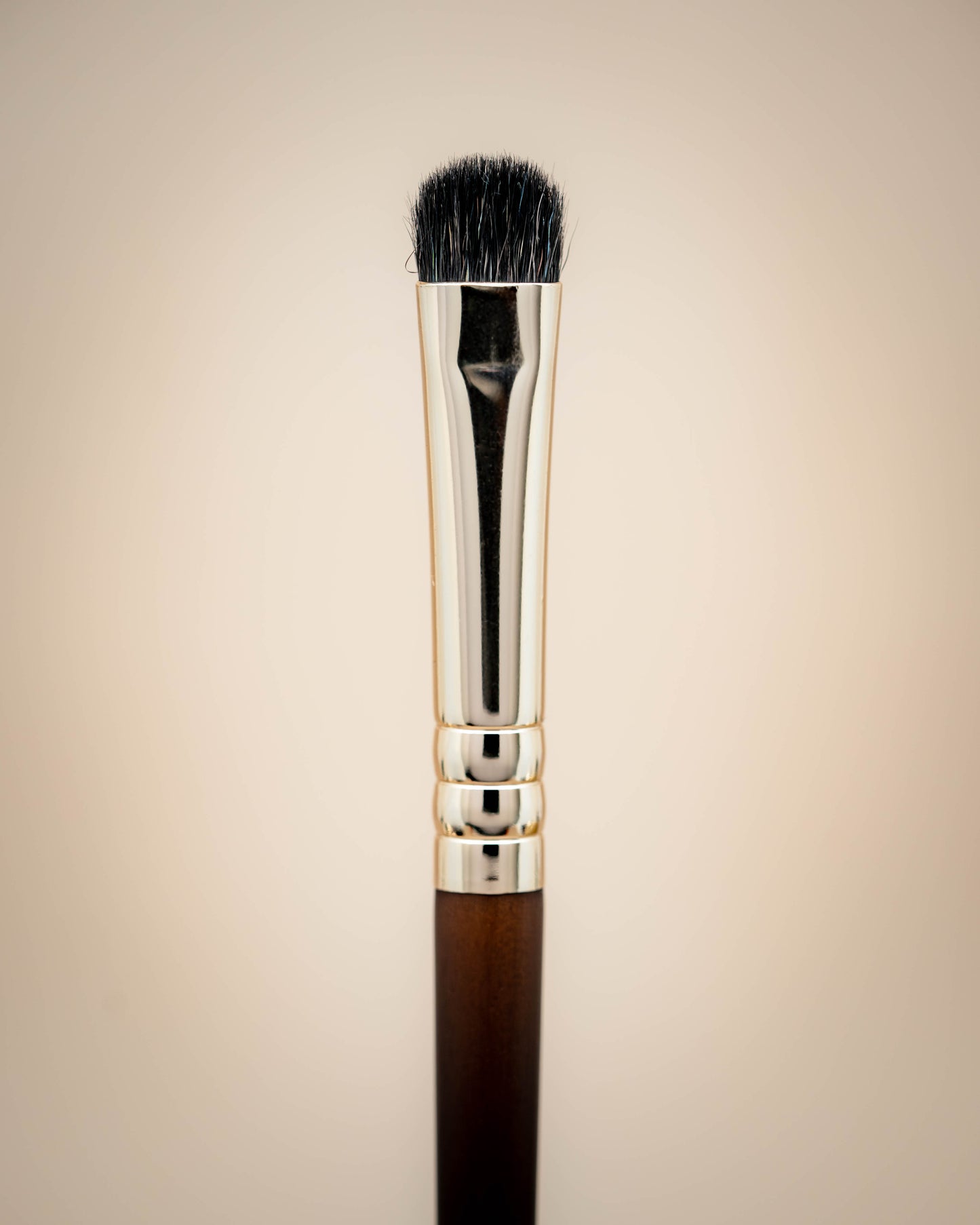 This is a flat synthetic lid brush and it has a wooden handle.